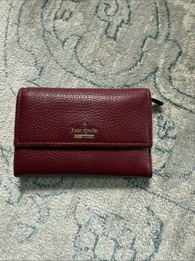 kate spade Pebbled Leather Trifold Wallet in Burgundy